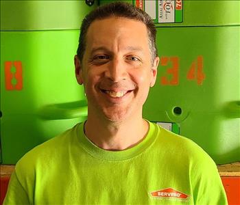 Crew Photo of a man with green t-shirt on and green machines in the background 