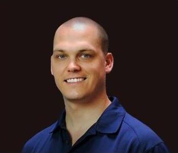 SERVPRO employee in front of black background,