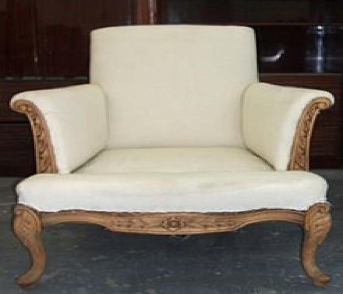 cream color arm chair with brown trim 