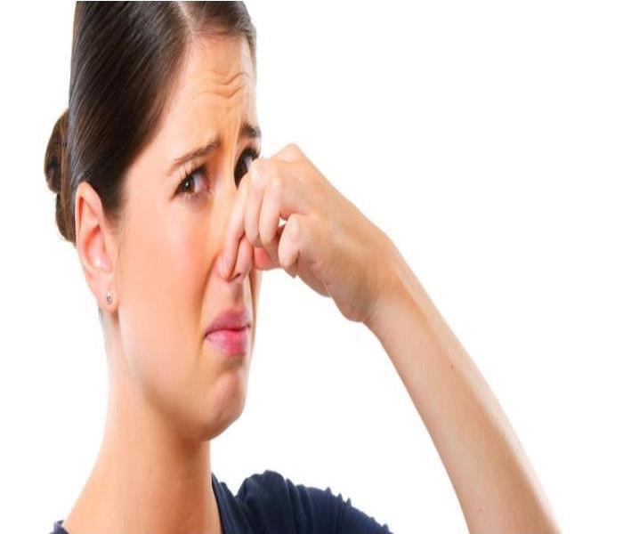 woman holding her nose form smelling something bad white background 
