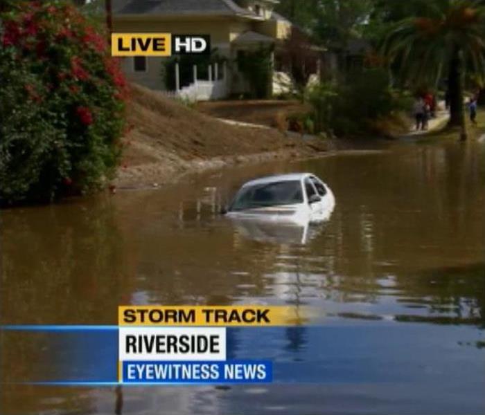 neiborhood flooded with water and white car submerged  