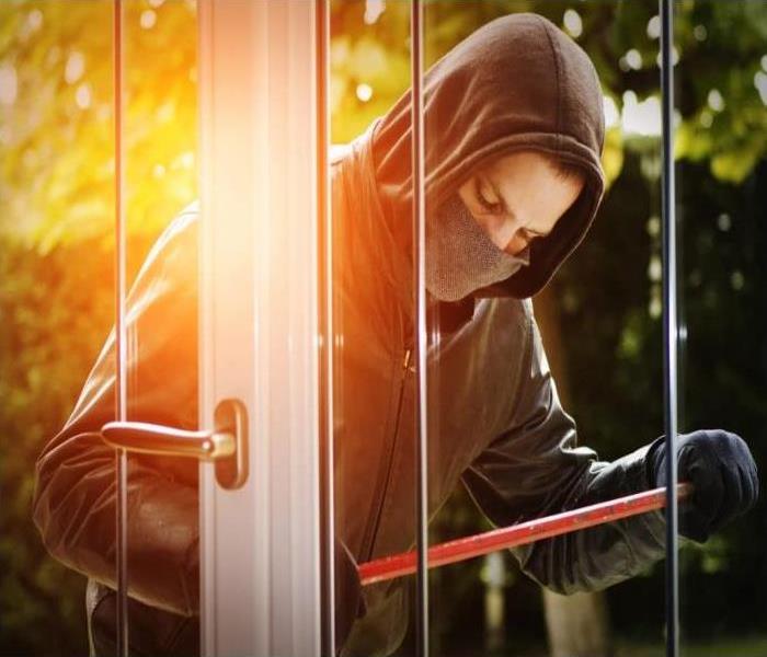 man wearing all black clothes breaking into home 