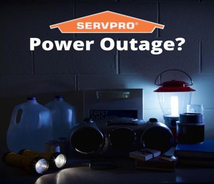 items for a power outage on a counter, water bottles, flashlights, radio, and lamp 